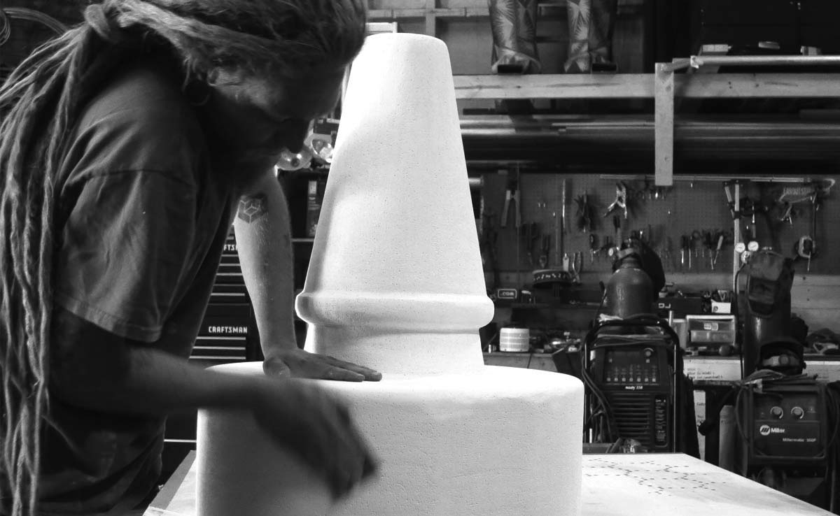 Picture of an Art Seen employee sanding the foam sculpture.