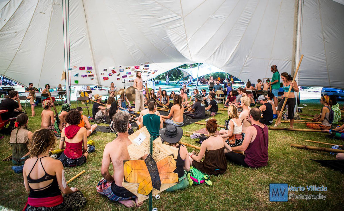 Picture of festival goers doing yoga in a tent.