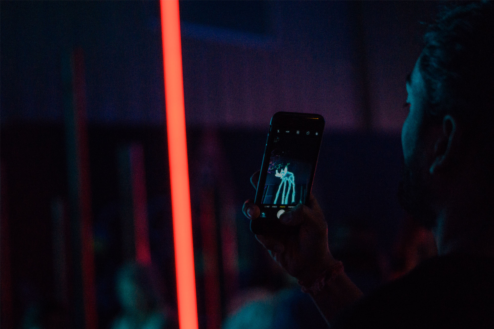 Picture of person taking a photo of neon.