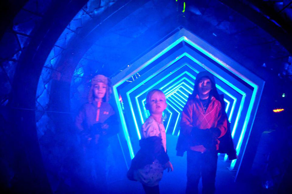 Picture of children in an LED pentagon tunnel.