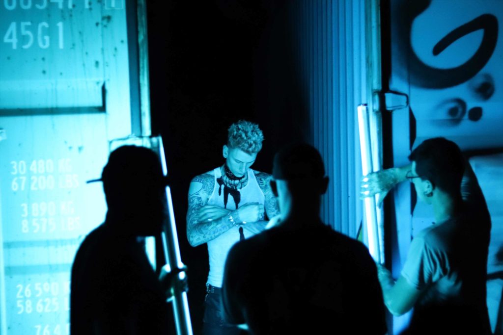 Picture of MGK engulfed in blue lighting. 