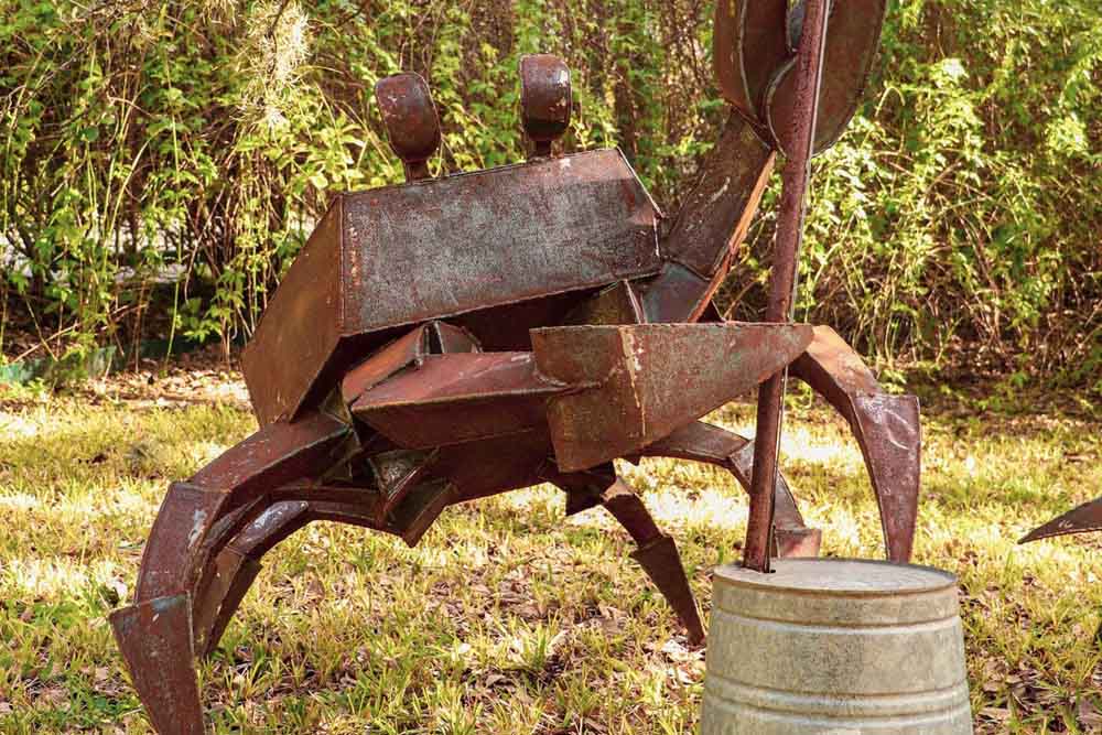 Picture of a steel sculpture, a crab playing the upright bass.