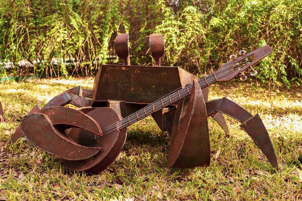 Picture of a steel sculpture, a crab playing the banjo.