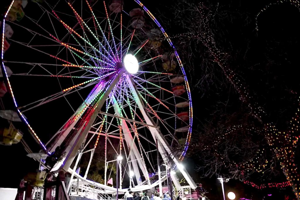 Picture of a ferris wheel lit up at night.