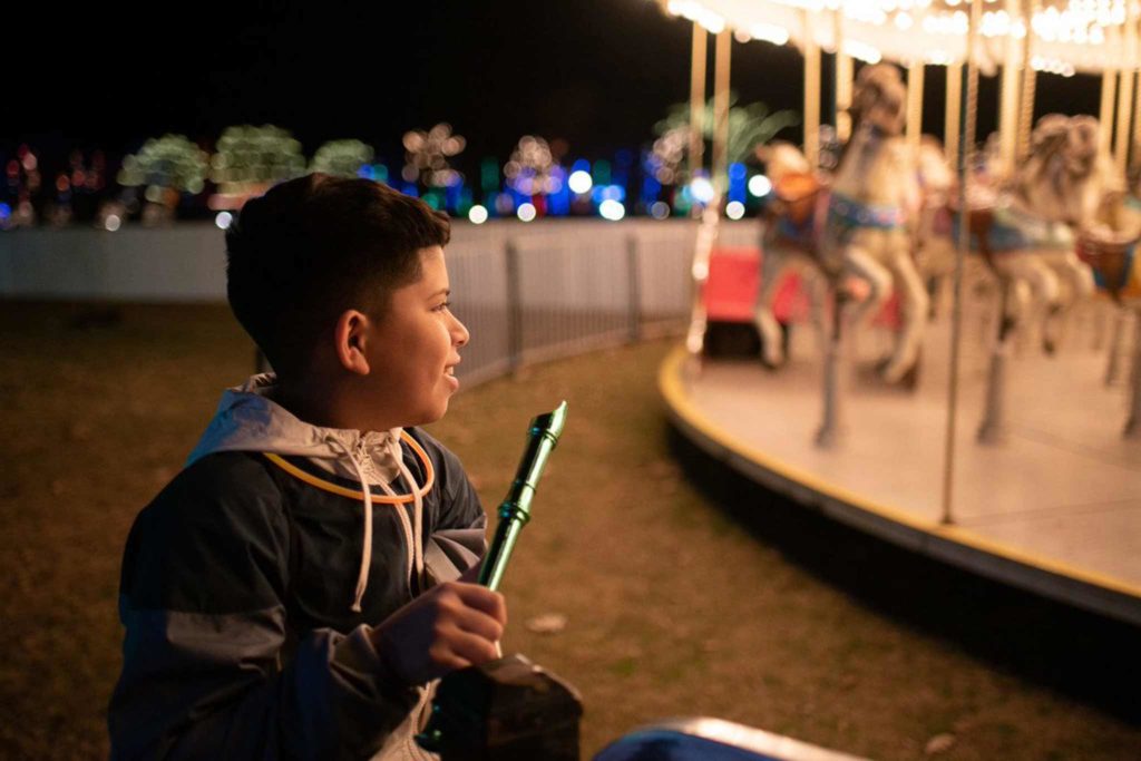 Picture of a child smiling at the carousel.