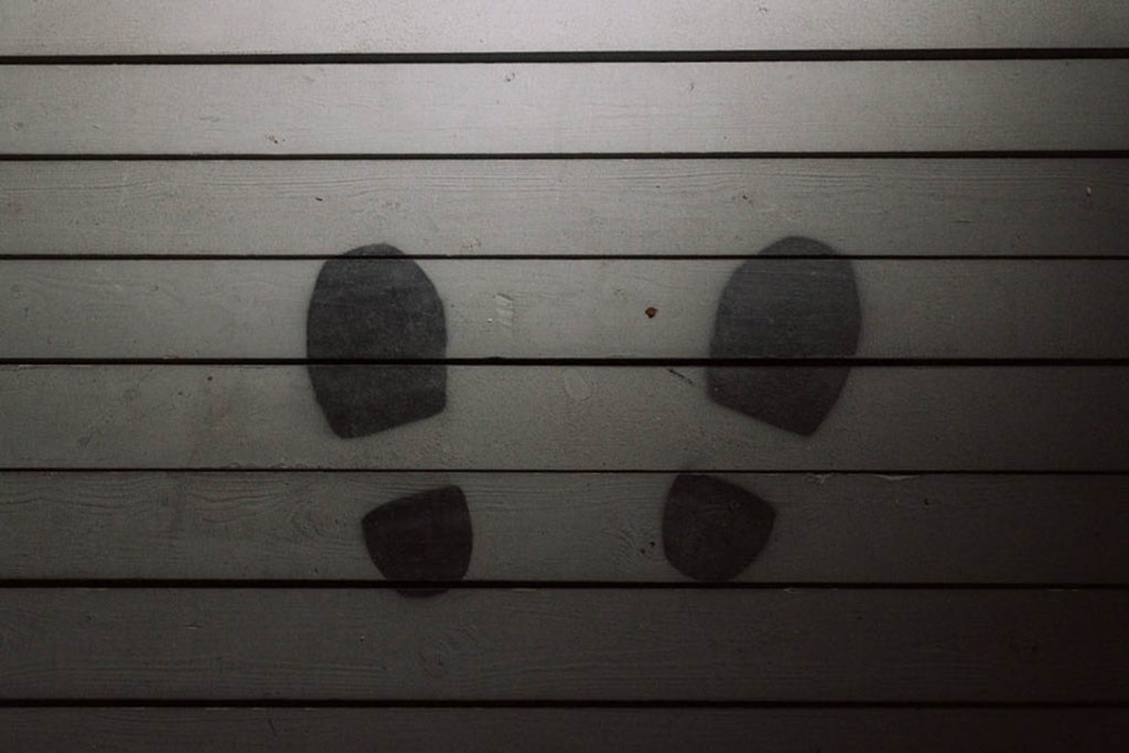 Picture of two footprints on wooden flooring inside the War Remains VR Experience.